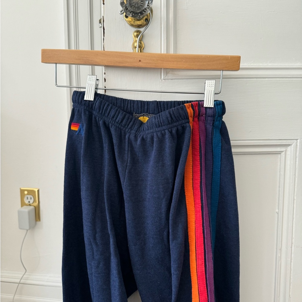 Aviator Nation dark blue sweatpants with red orange purple and blue stripes